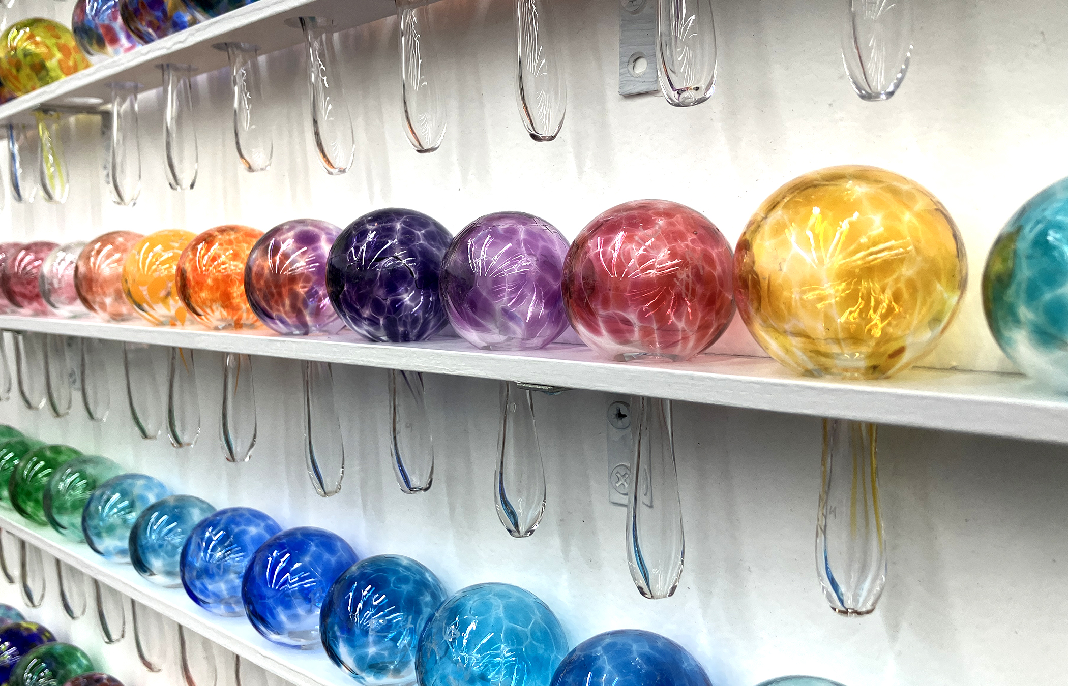 A rainbow of glass ornament balls on display