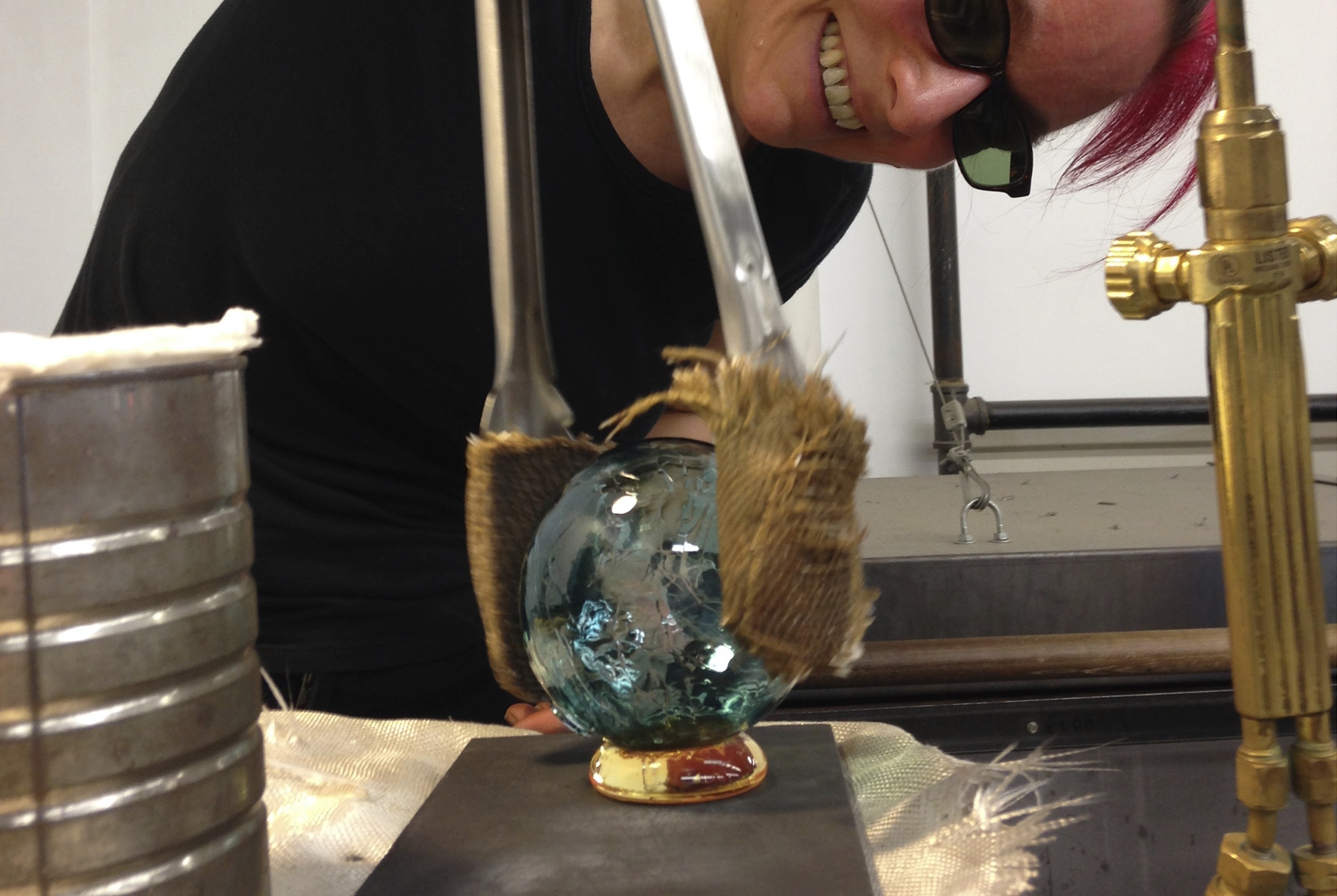 Henrietta shaping molten glass in the studio
